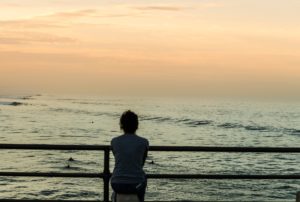 Woman struggling with anorexia sitting by the ocean