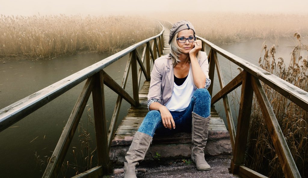 Woman sitting on a bridge struggling with disordered eating