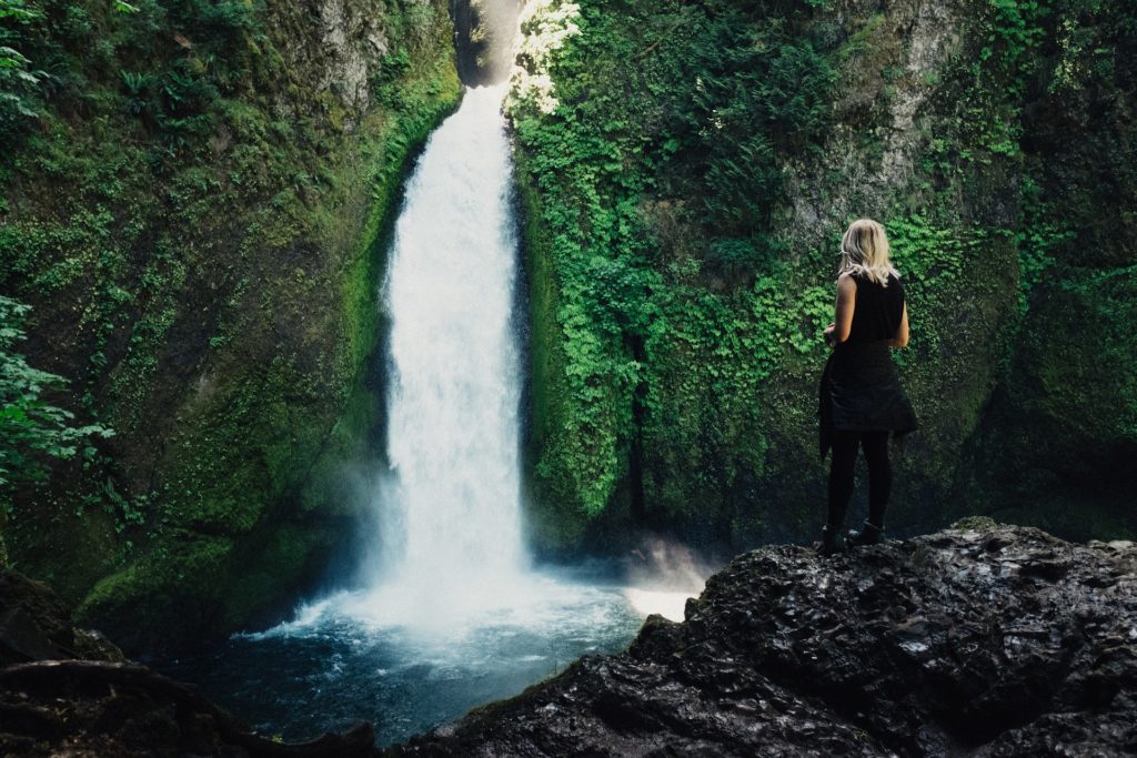 Woman near waterfall practicing self-care