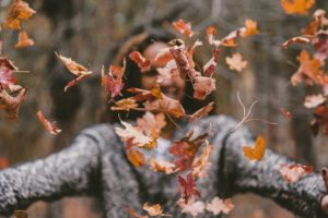 Woman throwing leaves using ACT in Binge Eating Disorder treatment