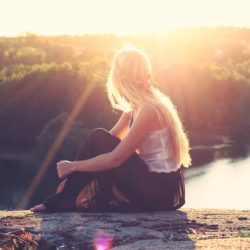 Woman with binge eating disorder seated by the river