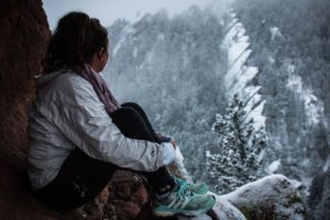 Woman sitting in the snow struggling with an eating disorder