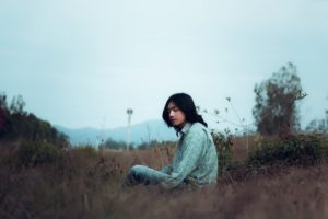 Man sitting in the grass struggling with body image