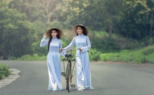 Girls from Vietnam walking with bicycle