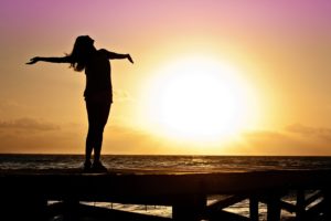 Woman standing in the sun celebrating her healing journey of eating disorder recovery