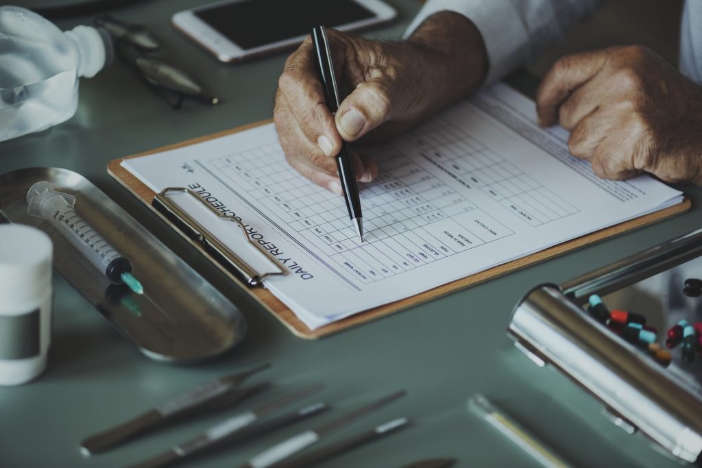 Doctor filling out form for medication-assisted treatments for depression