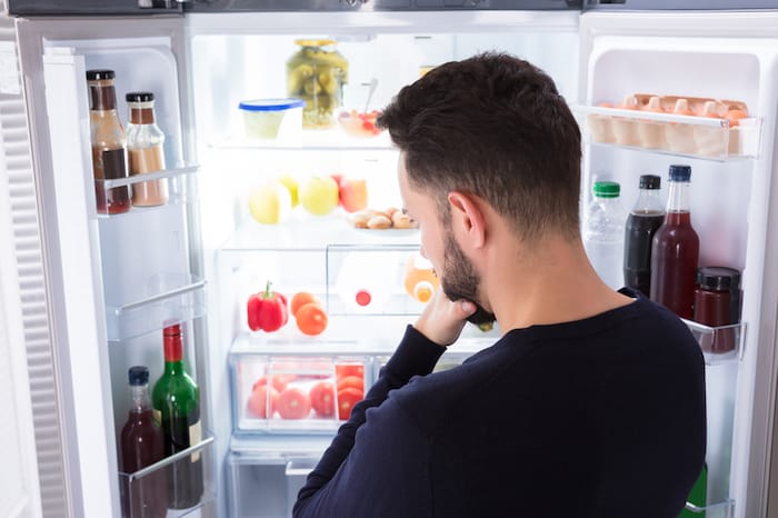 man looking in refrigerator 