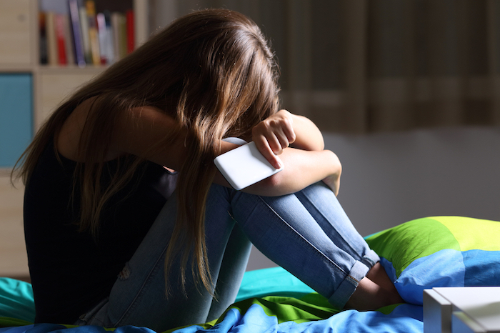 sad girl with phone in hand