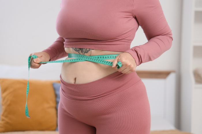 Person in larger sized body measuring themselves